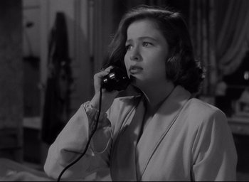 Movie still from “Sunset Blvd.” (1950), directed by Billy Wilder – A black and white photo of a woman talking on a phone; Close Up shot, High angle