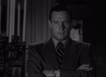 Movie still from “Sunset Blvd.” (1950), directed by Billy Wilder – A black and white photo of a man in a suit and tie; Close Up shot, Low angle