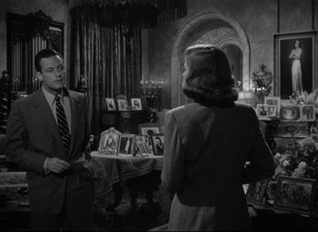 Movie still from “Sunset Blvd.” (1950), directed by Billy Wilder – A man and a woman are standing in front of a mirror; Medium shot, High angle