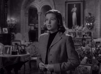 Movie still from “Sunset Blvd.” (1950), directed by Billy Wilder – A black and white photo of a woman in a suit; Medium shot, Low angle