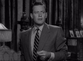 Movie still from “Sunset Blvd.” (1950), directed by Billy Wilder – A black and white photo of a man wearing a suit and tie; Close Up shot, Low angle