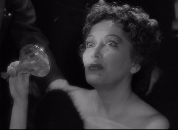 Movie still from “Sunset Blvd.” (1950), directed by Billy Wilder – An old photo of a woman holding a glass of wine; Close Up shot, Low angle