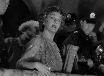 Movie still from “Sunset Blvd.” (1950), directed by Billy Wilder – An old photo of a woman in a crowd of people; Medium shot, Low angle