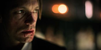 A man's face in front of an orange light