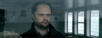 Movie still from “Suntan” (2016), directed by Argyris Papadimitropoulos – A person with a beard; Close Up shot, Over the shoulder angle