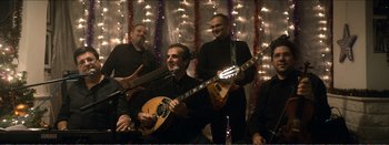 Movie still from “Suntan” (2016), directed by Argyris Papadimitropoulos – A group of men standing next to each other holding guitars; Wide shot, Low angle