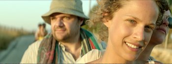 Movie still from “Suntan” (2016), directed by Argyris Papadimitropoulos – A man in a hat and a woman in a green hat; Close Up shot, Over the shoulder angle