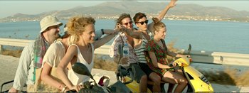 Movie still from “Suntan” (2016), directed by Argyris Papadimitropoulos – A group of young people sitting on a motorcycle; Medium shot, High angle
