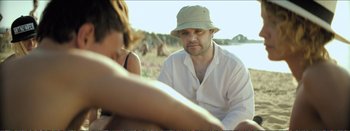 Movie still from “Suntan” (2016), directed by Argyris Papadimitropoulos – A man and a woman sitting on the beach; Medium shot, Over the shoulder angle