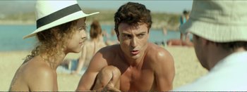 Movie still from “Suntan” (2016), directed by Argyris Papadimitropoulos – A man with a hat and a beard on a beach; Medium shot, Over the shoulder angle