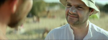 Movie still from “Suntan” (2016), directed by Argyris Papadimitropoulos – A person wearing a hat; Close Up shot, Over the shoulder angle