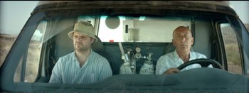 Movie still from “Suntan” (2016), directed by Argyris Papadimitropoulos – Two men sitting in the back of a vehicle; Medium shot, Low angle