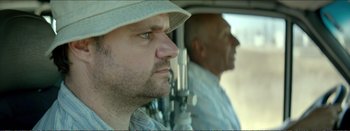 Movie still from “Suntan” (2016), directed by Argyris Papadimitropoulos – A man in a white hat and a man in a white shirt; Close Up shot, Low angle