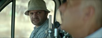 Movie still from “Suntan” (2016), directed by Argyris Papadimitropoulos – A person with a hat in a vehicle; Close Up shot, Over the shoulder angle