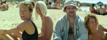 Movie still from “Suntan” (2016), directed by Argyris Papadimitropoulos – A man and a woman sitting next to each other on the beach; Medium shot, Over the shoulder angle