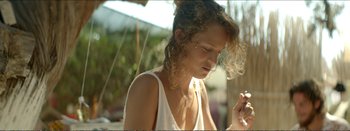 Movie still from “Suntan” (2016), directed by Argyris Papadimitropoulos – A person with curly hair looking down; Close Up shot, Low angle