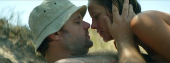 Movie still from “Suntan” (2016), directed by Argyris Papadimitropoulos – A man and a woman face to face in the grass; Close Up shot, Low angle