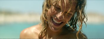 Movie still from “Suntan” (2016), directed by Argyris Papadimitropoulos – A person with wet hair smiling; Close Up shot, Over the shoulder angle