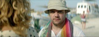 Movie still from “Suntan” (2016), directed by Argyris Papadimitropoulos – A person wearing a hat and a scarf; Close Up shot, Over the shoulder angle
