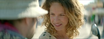 Movie still from “Suntan” (2016), directed by Argyris Papadimitropoulos – A woman smiling at the camera; Close Up shot, Over the shoulder angle