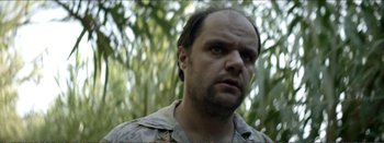 Movie still from “Suntan” (2016), directed by Argyris Papadimitropoulos – A person wearing a military uniform; Close Up shot, Low angle