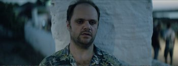Movie still from “Suntan” (2016), directed by Argyris Papadimitropoulos – A person wearing a floral shirt; Close Up shot, Low angle
