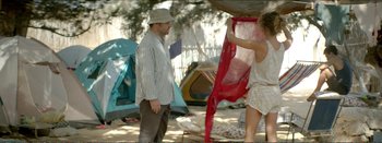 Movie still from “Suntan” (2016), directed by Argyris Papadimitropoulos – A man and a woman standing in front of a tent; Medium shot, Over the shoulder angle