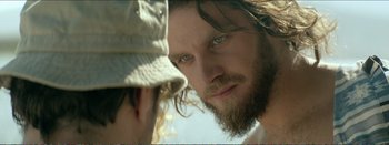 Movie still from “Suntan” (2016), directed by Argyris Papadimitropoulos – A person with a beard; Close Up shot, Over the shoulder angle