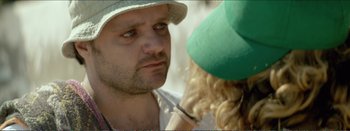Movie still from “Suntan” (2016), directed by Argyris Papadimitropoulos – A person wearing a hat; Close Up shot, Over the shoulder angle