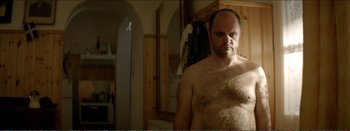Movie still from “Suntan” (2016), directed by Argyris Papadimitropoulos – A man with a hairy chest standing in front of a bathroom mirror; Close Up shot, Over the shoulder angle