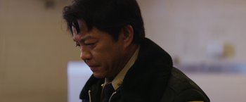 Movie still from “Super Dark Times” (2017), directed by Kevin Phillips – A person wearing a suit and tie; Close Up shot, Over the shoulder angle