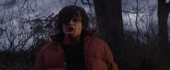 Movie still from “Super Dark Times” (2017), directed by Kevin Phillips – A man with a bloody face standing next to a tree; Close Up shot, Low angle