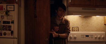 Movie still from “Super Dark Times” (2017), directed by Kevin Phillips – A young man standing in a dark kitchen; Medium shot, Over the shoulder angle