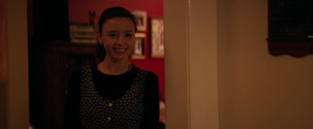 Movie still from “Super Dark Times” (2017), directed by Kevin Phillips – A woman standing in front of a mirror smiling for the camera; Close Up shot, Over the shoulder angle