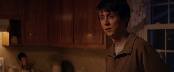 Movie still from “Super Dark Times” (2017), directed by Kevin Phillips – A young man standing in a kitchen in front of a counter; Close Up shot, Over the shoulder angle