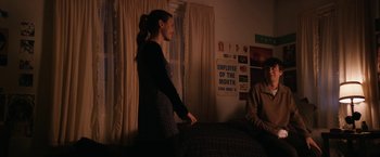 Movie still from “Super Dark Times” (2017), directed by Kevin Phillips – A woman standing next to a bed in a room; Medium shot, Over the shoulder angle