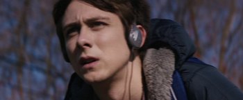 Movie still from “Super Dark Times” (2017), directed by Kevin Phillips – A young man wearing a backpack and ear buds; Close Up shot, Over the shoulder angle
