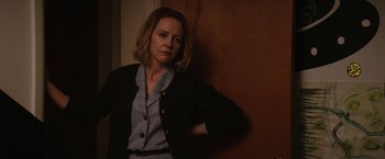 Movie still from “Super Dark Times” (2017), directed by Kevin Phillips – A woman leaning against a wall with her arms folded behind her back; Medium shot, Over the shoulder angle