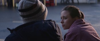 Movie still from “Super Dark Times” (2017), directed by Kevin Phillips – A woman sitting next to a man on a street; Close Up shot, Over the shoulder angle