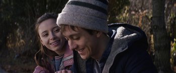 Movie still from “Super Dark Times” (2017), directed by Kevin Phillips – A man and a woman smiling for the camera; Close Up shot, Over the shoulder angle