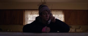 Movie still from “Super Dark Times” (2017), directed by Kevin Phillips – A person holding a cell phone in their hand; Medium shot, Low angle