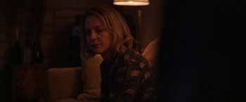 Movie still from “Super Dark Times” (2017), directed by Kevin Phillips – A woman sitting on a couch in the dark; Close Up shot, Over the shoulder angle