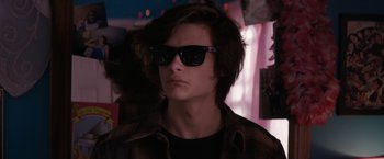 Movie still from “Super Dark Times” (2017), directed by Kevin Phillips – A young man wearing sunglasses looking at the camera; Close Up shot, Over the shoulder angle