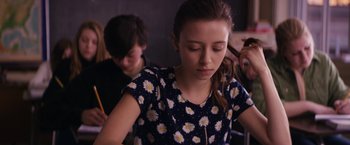 Movie still from “Super Dark Times” (2017), directed by Kevin Phillips – A young girl with her eyes closed in front of another young man; Medium shot, Over the shoulder angle
