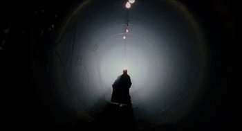 Movie still from “Super Mario Bros.” (1993), directed by Annabel Jankel – A person is standing in a dark tunnel; Wide shot, Low angle