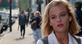 Movie still from “Super Mario Bros.” (1993), directed by Annabel Jankel – A woman with blonde hair is walking down the street; Close Up shot, Low angle