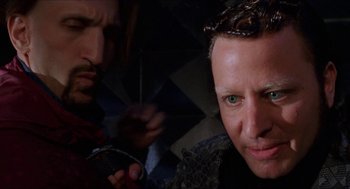 Movie still from “Super Mario Bros.” (1993), directed by Annabel Jankel – A man with green eyes is looking at the camera; Close Up shot, Over the shoulder angle