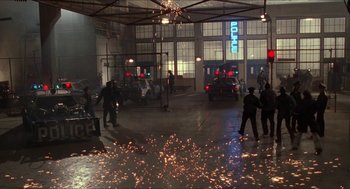 Movie still from “Super Mario Bros.” (1993), directed by Annabel Jankel – A group of people standing around in a building; Extreme Wide shot, High angle