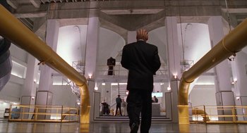 Movie still from “Super Mario Bros.” (1993), directed by Annabel Jankel – A man in a black suit is talking on a cell phone; Wide shot, Low angle