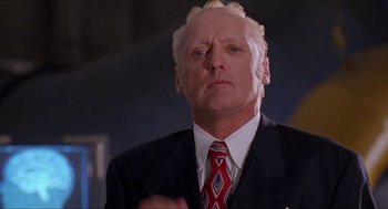 Movie still from “Super Mario Bros.” (1993), directed by Annabel Jankel – An older man in a suit and red tie; Close Up shot, Low angle